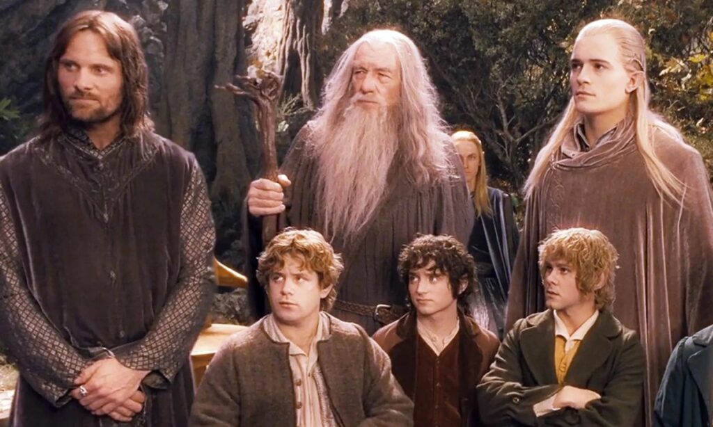 Aragorn, Gandalf, Legolas, Sam, Frodo, Merry, and Pippin from The Lord of the Rings standing and looking out of frame.